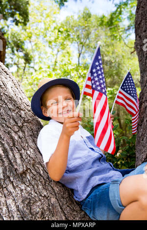 Adorable Little boy Holding amerikanische Flagge im Freien auf schönen Sommertag Stockfoto