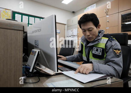 Ein koreanischer Polizist Befüllen einen Bericht in einer Polizeistation in der Stadt Seoul, Hauptstadt der Republik Korea allgemein bekannt als Südkorea. Stockfoto