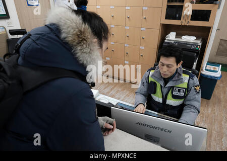 Ein koreanischer Polizist Befüllen einen Bericht in einer Polizeistation in der Stadt Seoul, Hauptstadt der Republik Korea allgemein bekannt als Südkorea. Stockfoto