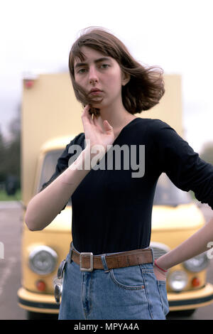 Portrait von selbstbewussten jungen Frau mit Hand in der Tasche auf der Rückseite stehend gegen Lkw Stockfoto