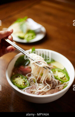 Close-up von Pho Suppe serviert in Schale auf Holztisch Stockfoto