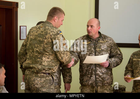 Ukrainische Oberstleutnant Pavlo Rozhko, der Kommandant der Yavoriv Combat Training Center, präsentiert ein Absolvent der CTC Beobachter Controller Trainer Akademie mit eine Ehrenurkunde während einer Abschlussfeier an der CTC International Peacekeeping und Security Center in der Nähe von Yavoriv, Ukraine, am 25 April. (Foto von Sgt. Anthony Jones, 45. Infanterie Brigade Combat Team) Stockfoto