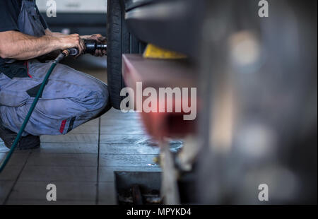Radwechsel - Bilanzierung / Reparatur von Rädern auf einem modernen Auto in einer Garage/Auto Service durch einen Mechaniker Stockfoto