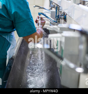 Chirurg im Krankenhaus Thorouughly seine Hände zu waschen, bevor Sie eine Operation durchführen (Farbe getönt Bild; flachen DOF) Stockfoto