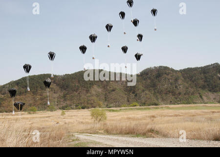 Low-cost aerial Delivery-Systeme, jeweils beladen mit vier, 55-Gallone Trommeln von Wasser, erreichen den Boden nach Fallenlassen von einer Republik der Korea Luftwaffe c-130, 12. April 2017, in einer Drop-Zone zwischen Daegu und Busan, Südkorea. ExOPR17 konzentriert sich auf die Integration der Republik Korea und USA Allianz Logistik-Funktionen in Luft, Land, See-, Raum und Informationen Umgebungen. Stockfoto