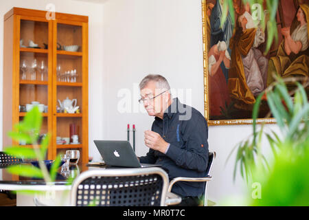 18 April 2018, Deutschland, Berlin: Der Rentner Rudolf Ruessmann an seinem Laptop in seiner Wohnung sitzt in Berlin. Ruessmann hält Korrespondenz mit Gefängnisinsassen. Foto: Christoph Soeder/dpa Stockfoto