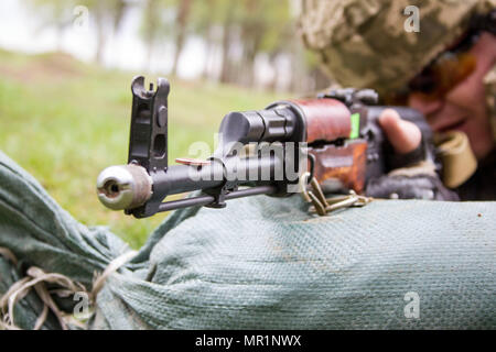 Ukrainische Soldaten mit der 1. Airmobile Bataillon, 79. Air Assault Brigade Praktiken feuert seine Waffe mit einer Münze auf seine Kugellauf während des Trainings am Yavoriv Combat Training Center auf der internationalen Friedenssicherung und Security Center in der Nähe von Yavoriv, Ukraine, am 29. April gelegt.  Bezeichnet einen Groschen Bohrer durch US-Truppen, üben Soldaten quetschen ihre Auslöser bis die Waffe Feuer - ohne die Waffe geladen - bis sie in der Lage zu tun, ohne die Münze fallen. Diese Bohrmaschine lehrt Soldaten, wie man Feuer ohne Rucken den Auslöser, wodurch die Runde seine t verpassen Stockfoto