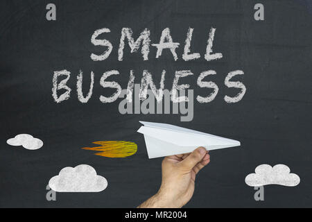 Hand, die eine neue Ebene und Small Business Wörter auf Tafel. Stockfoto