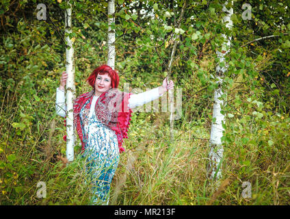 Junge schöne Mädchen mit einem Taschentuch auf ihre Schultern in der Nähe von eine Birke im Wald Stockfoto