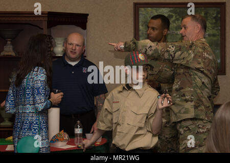 Generalmajor Walter Piatt, 10th Mountain Division und Fort-Trommel Kommandierender General und seine Frau Cynthia, sprechen Sie mit Sgt. 1. Klasse Michael Bogels, Fort Drum Culinary Arts Team Leader, an ihrem Tisch während der 26. jährliche International Festival of Foods in die Commons auf Fort-Trommel 28.April. Die Boy Scouts von Fort Drum Pack 26 freiwillig ihre Zeit, Punsch Tickets und mit Aufräumen helfen bei der Veranstaltung. Stockfoto