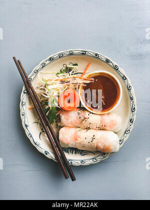 Abendessen im asiatischen Stil. Flachbild-lay aus gedämpftem dumplings Dim Sum und Sommer Reis Papierrollen mit Garnelen und Soße über blauen Tabelle, Ansicht von oben, kopieren. Chinesische Küche Stockfoto