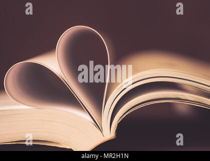 Soft Focus Seiten eines Buches in Form eines Herzens gebogen. Liebe und Valentinstag Konzept. Stockfoto
