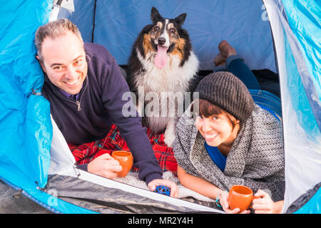 Junges Paar genießen Sie den Campingplatz. Zwei Leute und der Hund wie eine Familie. Outdoor am Strand vor dem Ozean Stockfoto