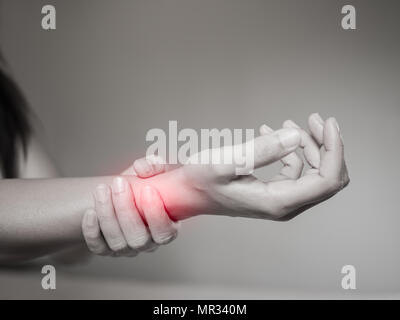 Schwarze und weiße Frau hält Ihr Handgelenk Handverletzung, Gefühl, Schmerz. Gesundheit und medizinische conept. Stockfoto