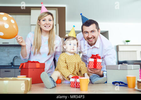 Eine Familie mit einem Kuchen gratuliert ein glückliches Kind an seinem Geburtstag Stockfoto
