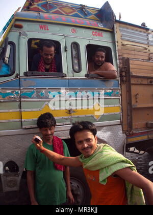 Indische Kerl Handeln für ein Foto mit einem Bus, Kolkata, Indien, 11. APRIL 2013. Stockfoto