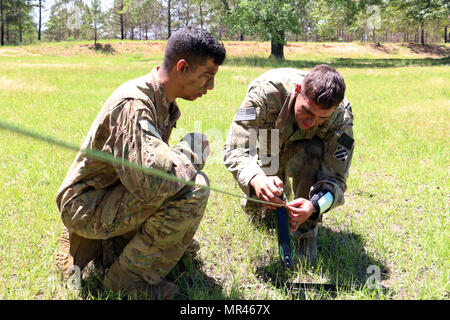 Sgt. Evan Gunther (rechts), Teamleiter mit der 3. US-Infanteriedivision Mannschaft für die Gainey Cup-Wettbewerb, stellt Kabel für eine Harris 150 Radioapparat während einer Kommunikation Gasse 3. Mai 2017 in Fort Benning, Georgia. 3. ID Kader wurde zweite im 2017 Gainey Cup-Wettbewerb, das die Kompetenz zur Schau stellt, körperliche und geistige Ausdauer und Kampfgeist der Aufklärung Soldaten in Recon und Kavallerie Formationen. (US Armee-Foto von Staff Sgt. Candace Mundt/freigegeben) Stockfoto