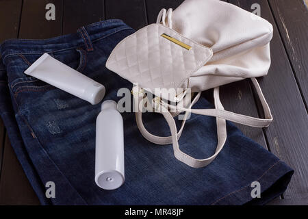 Jute Rucksack oder Sack Rucksack mit kosmetischen Flasche, auf schwarzem Hintergrund Stockfoto