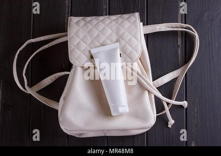 Jute Rucksack oder Sack Rucksack mit kosmetischen Flasche, auf schwarzem Hintergrund Stockfoto