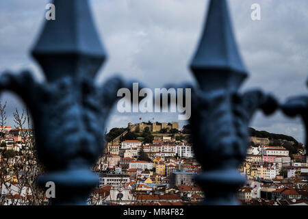 Ein Blick auf die Dächer der Stadt in Richtung des Schlosses durch Geländer in Lissabon, Portugal. Stockfoto