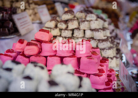 Viele verschiedene Arten von Marzipan sind in Stapeln angeordnet. Es gibt Geschmacksrichtungen wie Schokolade, Vanille, Erdbeere, Rosinen, Kokosnuss und mehr. Stockfoto