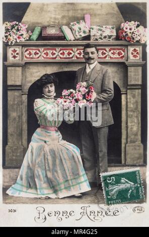 Französische Postkarte datiert um 1900 und zeigt eine junge romantische Paar teilen Blumen Stockfoto