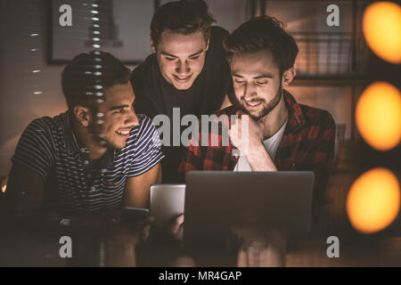 Gruppe von aufgeregt friends Fotos auf einem Tablet-PC zusammen Stockfoto