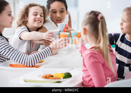 Multikulturelle Gruppe von Kindern toasten während der Geburtstagsfeier zu Hause Stockfoto