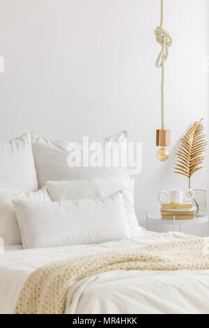 Weiß, minimalistischen Schlafzimmer Innenraum mit close-up auf dem Bett mit Kissen und Gold Dekorationen Stockfoto