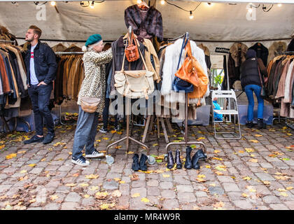 Berlin Prenzlauer Berg. Mauerpark Flohmarkt. Junge trendige Shopper an Second Hand Kleidung stall verkaufen Mäntel, Taschen und Schuhe Stockfoto