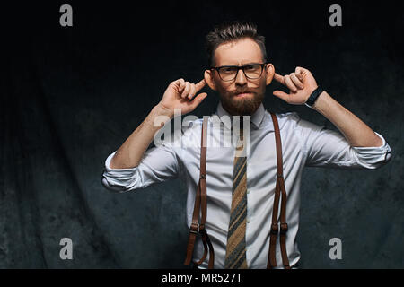 Junge stilvolle hipster Unternehmer oder Manager ist Stretching seine Ohren, imitieren Affe in eine lustige Weise oder das Vortäuschen nicht hört jemand Rede oder andere Geräusche Stockfoto
