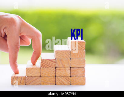 Business Achievement, KPI-wachstum Konzept. Frauen Hand Finger Fuß auf gestapelten Holzblock wie Treppen. Stockfoto