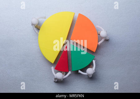 Erhöhte Ansicht von der menschlichen Figuren Verbindungsstücke von bunten Kreisdiagramm auf grauem Hintergrund Stockfoto