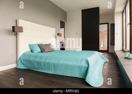 Grau gepolstert Schlafzimmer mit grossem Bett und ice blue Bettwäsche Stockfoto