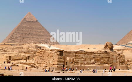 Die Große Sphinx von Gizeh gegen die Pyramide des Cheops. Kalkstein Statue eines liegenden Sphinx, ein Fabelwesen mit dem Körper eines Löwen und den Kopf eines Menschen. Direkt gegenüber von Westen nach Osten, es steht auf dem Plateau von Gizeh am Westufer des Nils in Gizeh, Ägypten. Das Antlitz der Sphinx wird allgemein angenommen, die den Pharao Khafre zu vertreten. Ausschneiden aus dem Gestein, die ursprüngliche Form des Sphinx wurde wiederhergestellt. Er misst 238 Fuß (73 m) lang (ca. 2558-2532 v. Chr.). Stockfoto