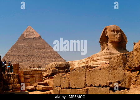 Die Große Sphinx von Gizeh gegen die Pyramide des Cheops. Kalkstein Statue eines liegenden Sphinx, ein Fabelwesen mit dem Körper eines Löwen und den Kopf eines Menschen. Direkt gegenüber von Westen nach Osten, es steht auf dem Plateau von Gizeh am Westufer des Nils in Gizeh, Ägypten. Das Antlitz der Sphinx wird allgemein angenommen, die den Pharao Khafre zu vertreten. Ausschneiden aus dem Gestein, die ursprüngliche Form des Sphinx wurde wiederhergestellt. Er misst 238 Fuß (73 m) lang (ca. 2558-2532 v. Chr.). Stockfoto