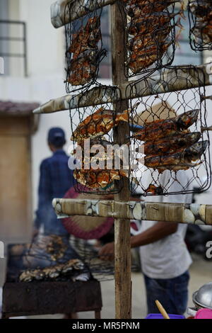 Essen Anbieter kocht und verkauft Grill Fisch auf dem Markt in der Stadt Banda Aceh Stockfoto