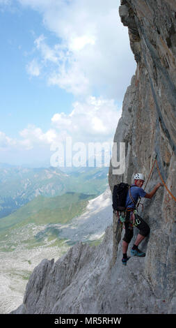 Männliche Bergsteiger auf einem steilen Felsen klettern Route in den Schweizer Alpen in der Nähe von Klosters Stockfoto