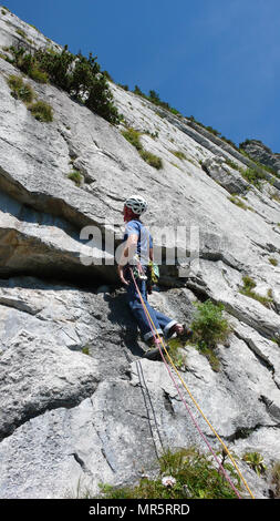 Bergführer an einem steilen Platte Tonhöhe einer hard rock climbing Route in den Alpen der Schweiz Stockfoto