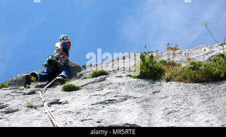 Bergführer an einem steilen Platte Tonhöhe einer hard rock climbing Route in den Alpen der Schweiz Stockfoto