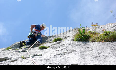 Bergführer an einem steilen Platte Tonhöhe einer hard rock climbing Route in den Alpen der Schweiz Stockfoto