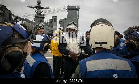 Pazifischer Ozean – Petty Officer 2. Klasse Deshawn Byers, einem Bootsmann Mate an Bord USS Pearl Harbor (LSD-52), informiert Marines mit bekämpfen Logistik-Bataillon 15, die Logistik Combat Element des 15. Marine Expeditionary Unit und Segler mit Decksbereich, den Plan des Tages vor der Durchführung einer vertikalen Nachschub Mission als Teil des zusammengesetzten Einheit Trainingsübung, Mai 11 , 2017. Die Fähigkeit der Nachschub auf hoher See gibt die 15. Marine Expeditionary Unit und die Amerika amphibische bereit Gruppe Mobilität und Nachhaltigkeit benötigt um einen asymmetrischen Vorteil gegenüber Adversa zu halten Stockfoto
