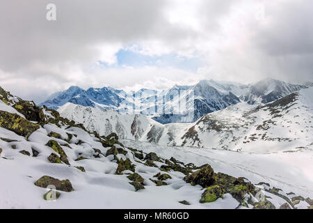 Snowy Mountains aero Foto Drone, Wolken Berge und das Tal. Stockfoto