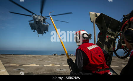 Pazifischer Ozean – Lance Cpl. Kieran Hayes mit bekämpfen Logistik-Bataillon 15, der Logistik zu bekämpfen Bestandteil der 15. Marine Expeditionary Unit wartet, während ein CH-53E Super Stallion-Hubschrauber mit Marine Medium Tiltrotor Squadron 161 (Reinforced) in Position bewegt sich Anfügen einer M-777 Haubitze an Bord USS Pearl Harbor (LSD-52) als Bestandteil einer Hubschrauber-Unterstützungsaktion Team wo wird es dann ans Ufer während zusammengesetzte Übung Einheit transportiert werden , 3. Mai 2017. COMPTUEX testet die LCE-Fähigkeit, Personal und Ausrüstung vom Meer in Richtung land demonstriert die amphibische Kraft Extensi bewegen Stockfoto