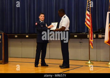 Jüngsterer Sohn Oberst Carlos Perez stellt ein Zertifikat Oberst James Grace während der Aktivierungszeremonie für Randolph High School Junior Reserve Officer Training Corps Einheit.  Grace ist der senior Luft-und Raumfahrt Wissenschaft Lehrer am nahe gelegenen Judson HS wo mehrere RHS Studenten ROTC besuchte, bevor ihr eigenes Programm aktiviert wurde.  Perez, Senior, Absolventen in diesem Jahr und der Naval Academy Preparatory School teilnehmen. (US Air Force Foto von Randy Martin) 170517-F-ET654-002 Stockfoto