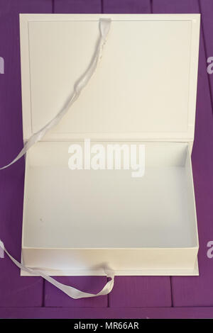 Öffnen Geschenkbox auf Purple vintage Holzschreibtisch Ansicht von oben. Stockfoto