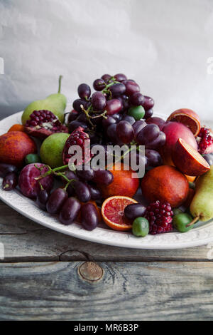 Frischer Obstteller mit Granatapfel, Trauben und Birnen Stockfoto