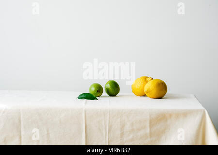 Minimalistische Komposition mit Zitrusfrüchten auf eine Tabelle mit weißen Tischtüchern bedeckt Stockfoto