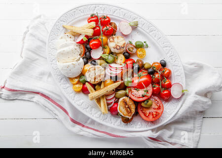 Frisch und pikant Salat mit Tomaten und Mozzarella auf einer Servierplatte mit Gewürzen serviert Stockfoto