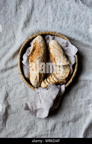 Glutenfreies Baguette, Käse und Öl auf ein graues Leinen Hintergrund Stockfoto